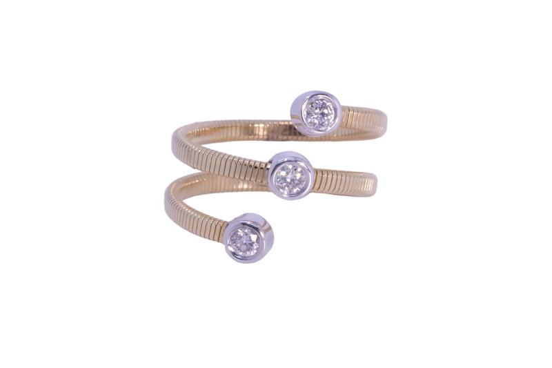 A gold snake-style ring with three bezel-set clear round gemstones, photographed on a light lavender background.