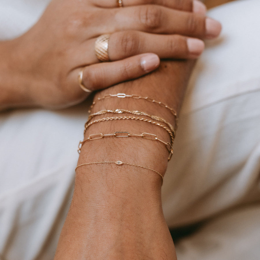 model wears Ayla Evil Eye Bracelet at the bottom of stack. in 14 k gold.